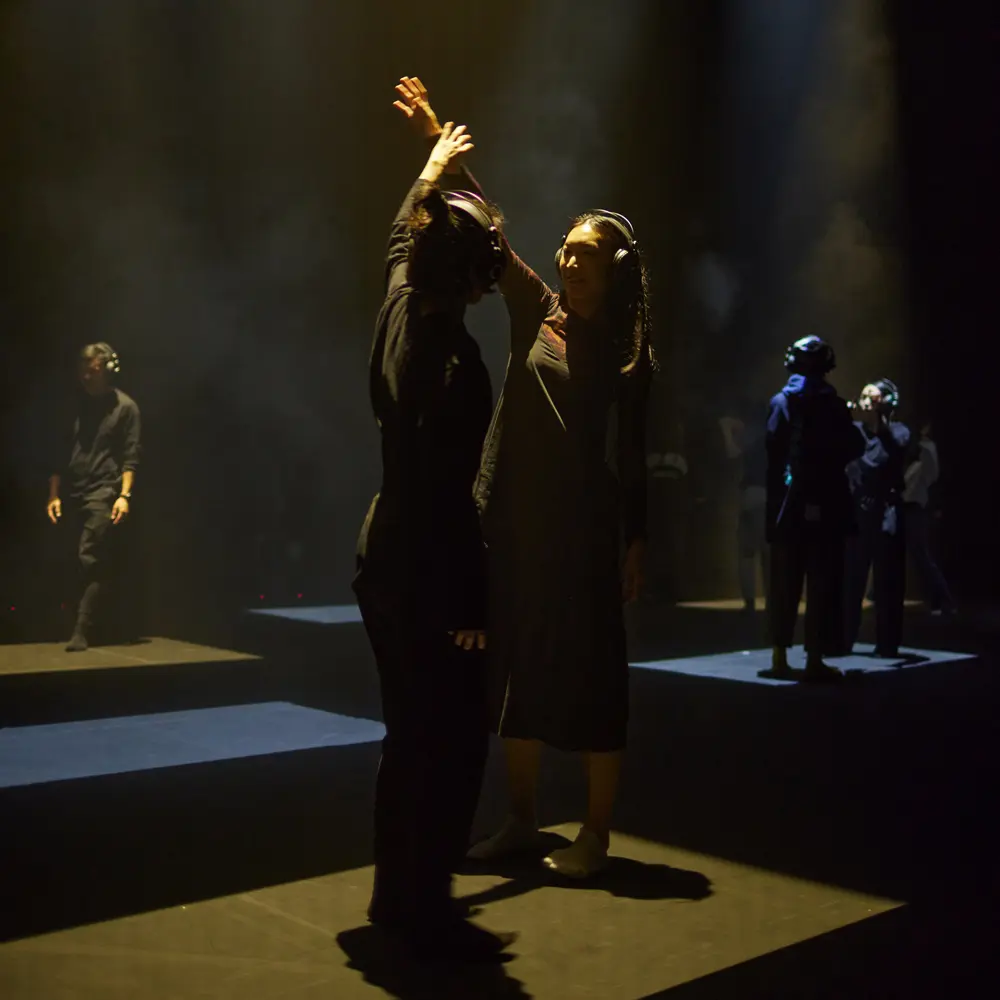 Un aperçu de la scène, avec différents groupes de personnes dançant sous une lumière orange