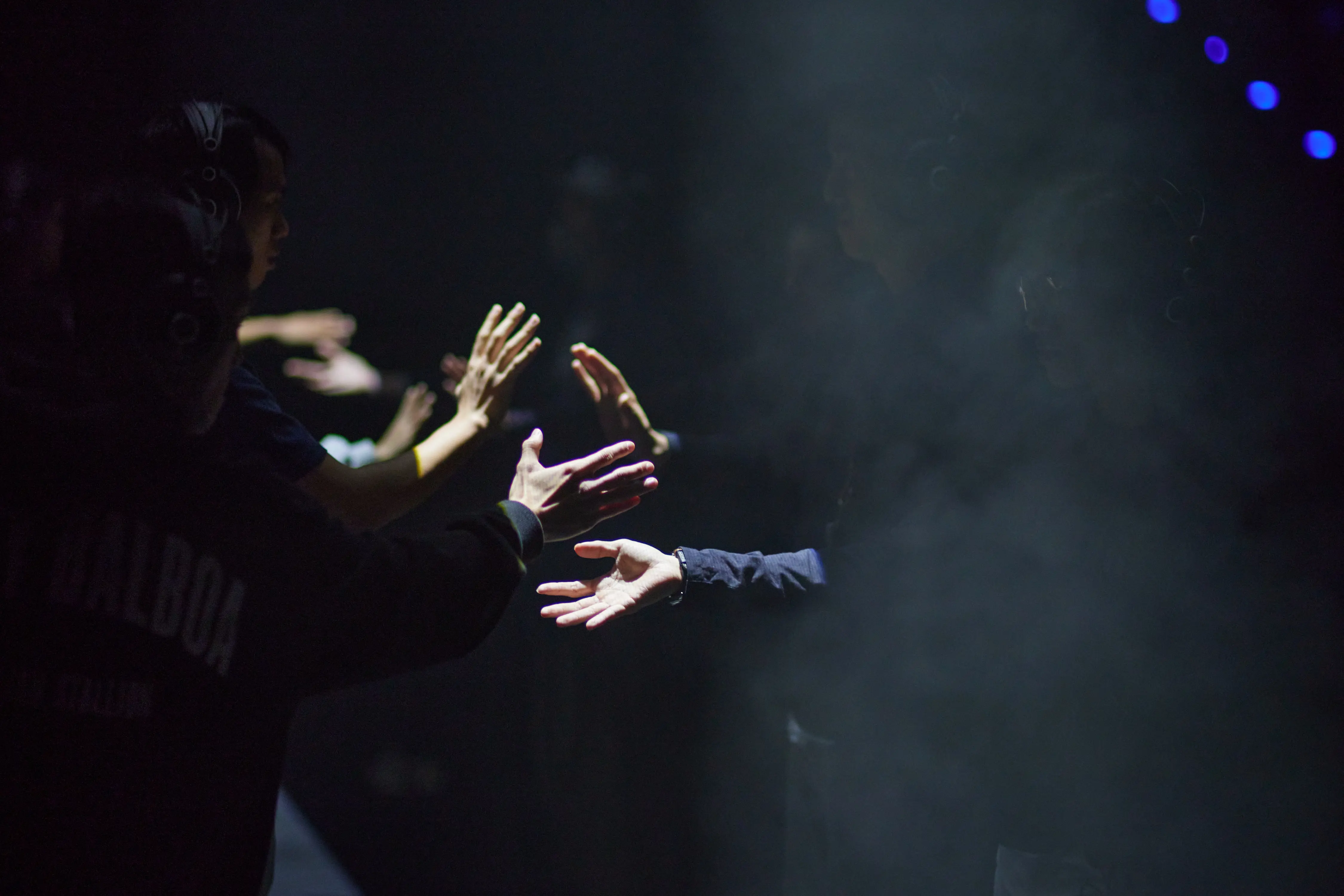 Sur un plateau sombre, on voit seulement les mains des participants, 
          qui semblent dancer